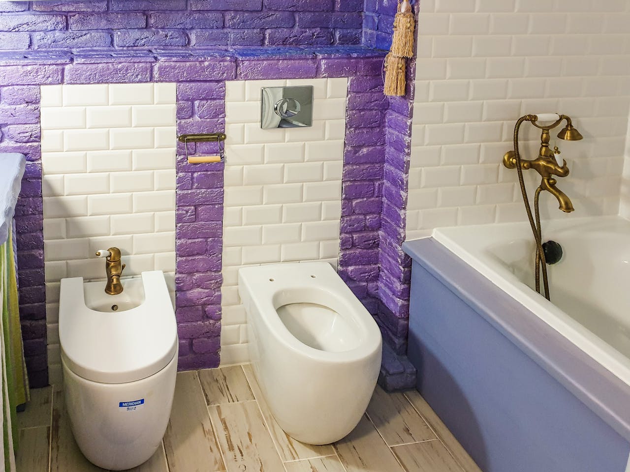 services-01 Stylish bathroom featuring a bidet and bathtub with vibrant purple and white tiles.